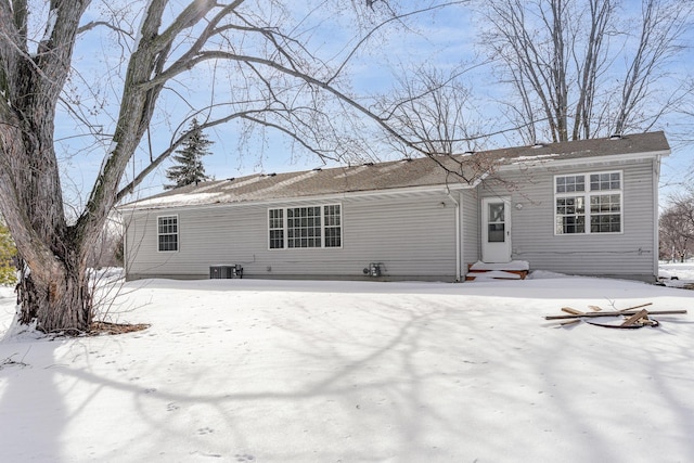 snow covered property featuring central AC