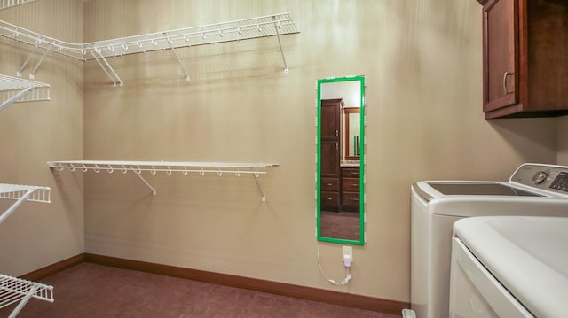 laundry area featuring baseboards, cabinet space, and washer and clothes dryer