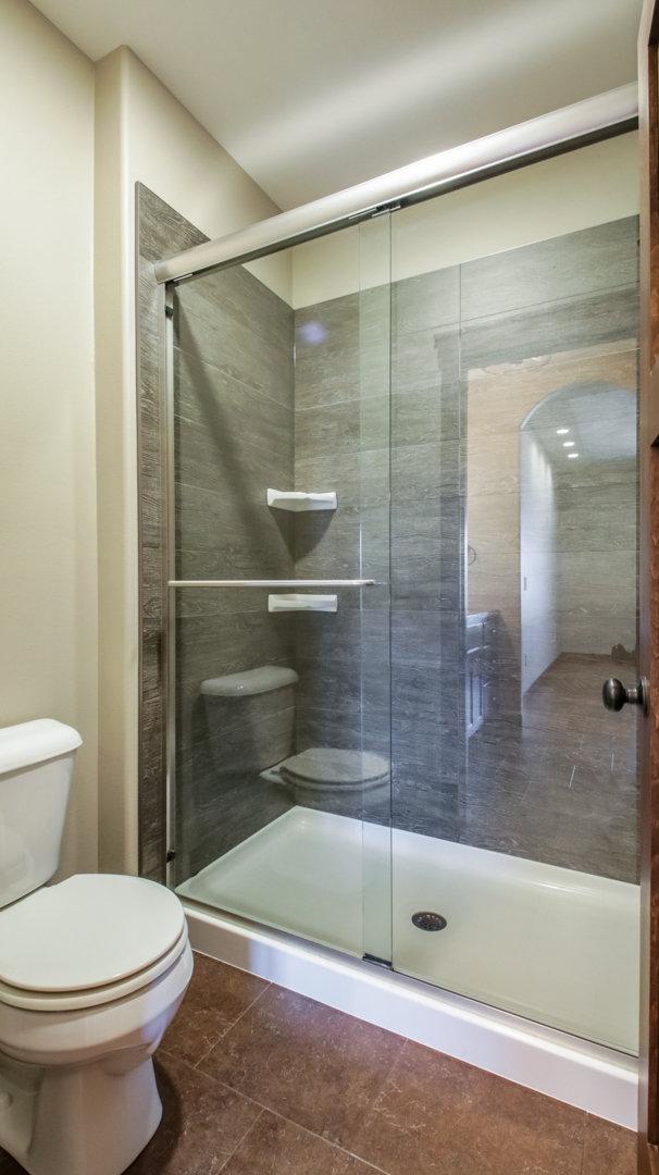 bathroom with toilet and a stall shower