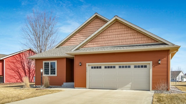 view of front of house with a garage, roof with shingles, and concrete driveway