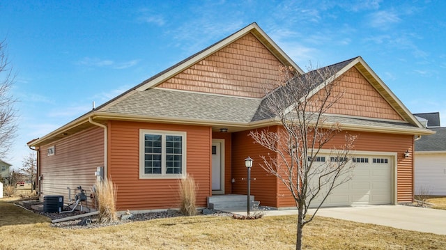 view of front of property featuring central air condition unit, a garage, driveway, and a shingled roof