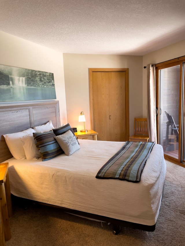 carpeted bedroom featuring access to exterior, a textured ceiling, and a closet