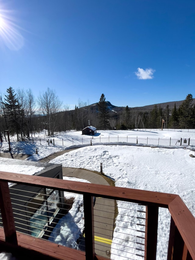 snowy yard with fence and a mountain view