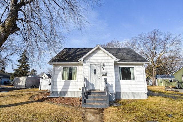 bungalow-style house featuring a front yard and a shingled roof