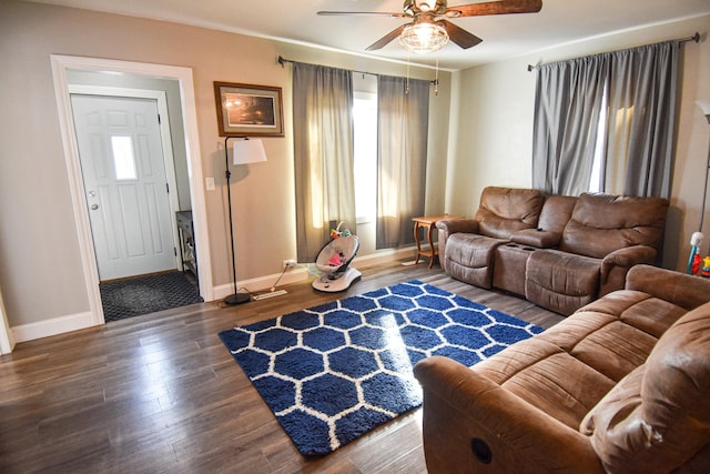 living area with baseboards, a ceiling fan, and wood finished floors