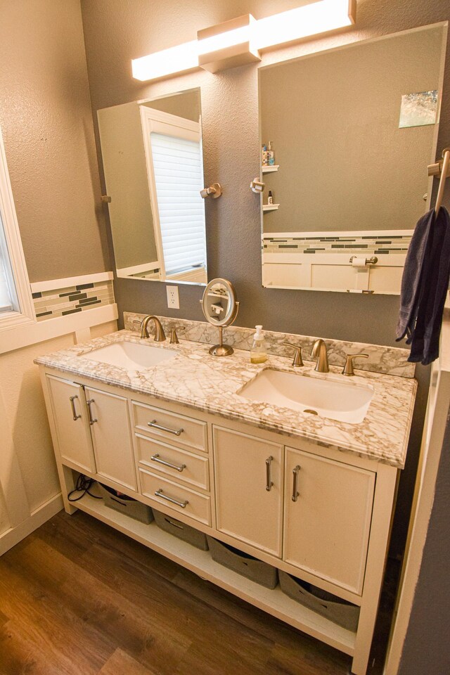 full bathroom featuring a sink, wood finished floors, and double vanity