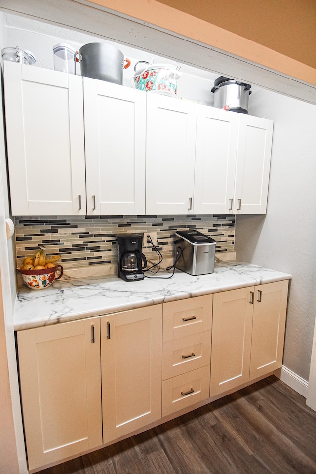 interior space featuring tasteful backsplash, dark wood-style floors, white cabinets, and light stone countertops