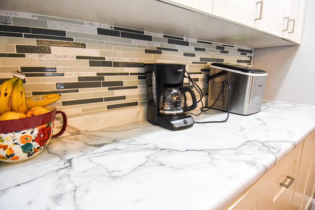 interior details with white cabinetry and light stone countertops