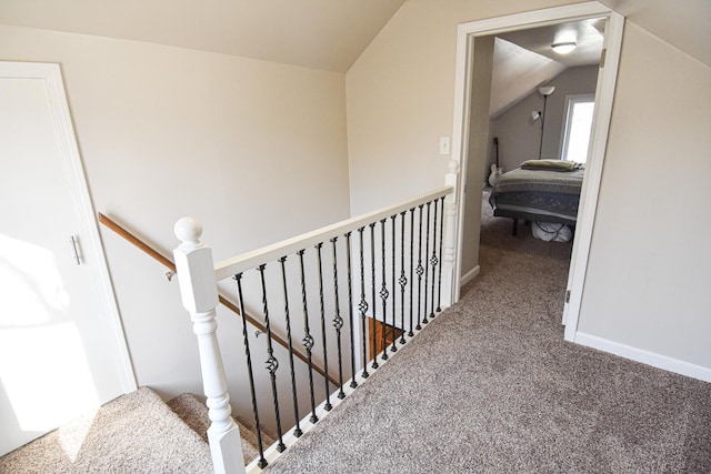 stairs with vaulted ceiling, baseboards, and carpet floors