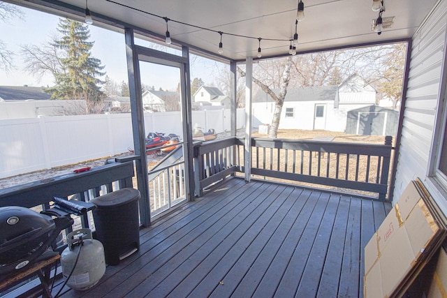 sunroom / solarium with a residential view and track lighting