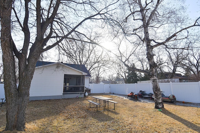 view of yard featuring a fenced backyard and a sunroom