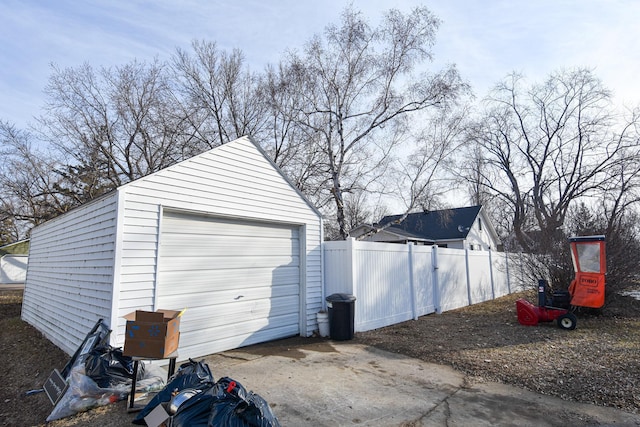 detached garage with driveway and fence