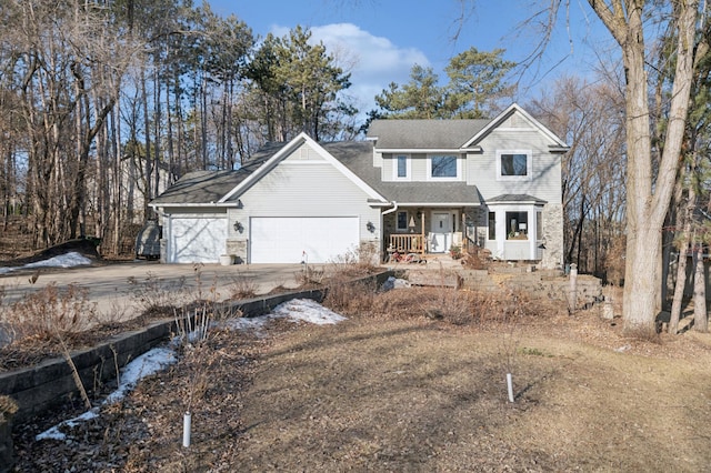 traditional-style house with a porch, an attached garage, and concrete driveway