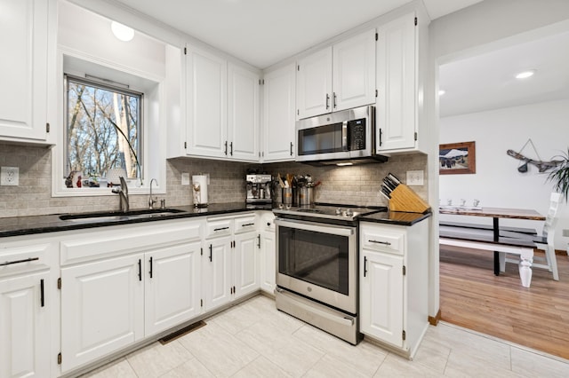 kitchen featuring a sink, visible vents, appliances with stainless steel finishes, and white cabinetry