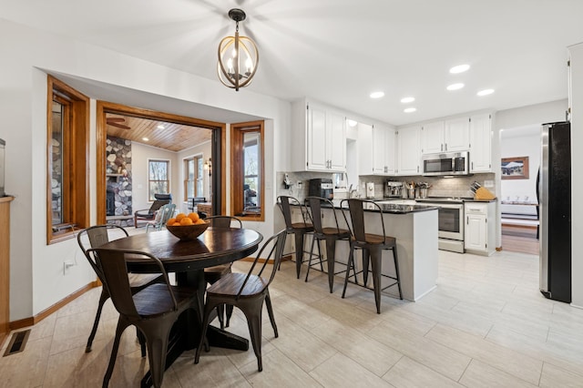 dining room with a notable chandelier, visible vents, recessed lighting, and baseboards