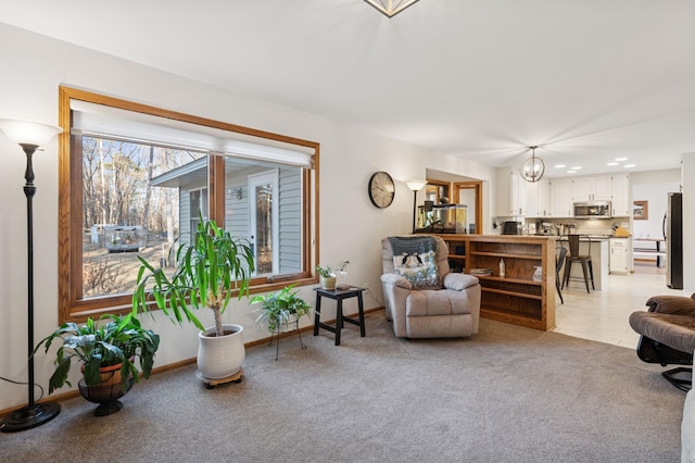 sitting room featuring recessed lighting, a notable chandelier, light colored carpet, and baseboards