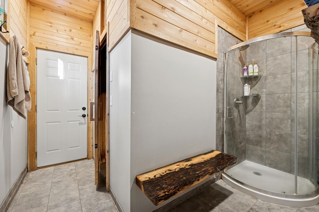 bathroom featuring tile patterned flooring, wooden walls, a shower stall, and wood ceiling