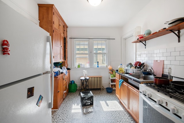 kitchen featuring open shelves, a sink, tasteful backsplash, radiator heating unit, and white appliances