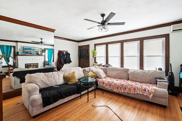living room featuring a brick fireplace, a ceiling fan, light wood-style flooring, ornamental molding, and an AC wall unit