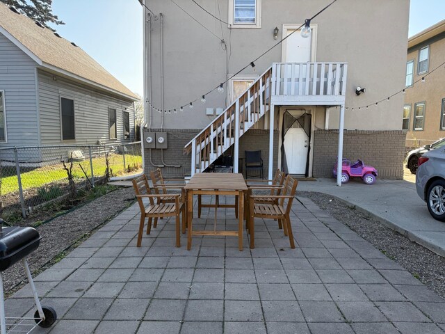 view of patio / terrace featuring area for grilling, outdoor dining area, stairway, and fence