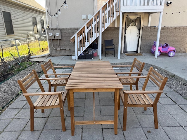 view of patio / terrace with fence, outdoor dining space, and stairs