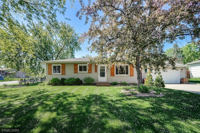 ranch-style home featuring a front lawn, a garage, and driveway