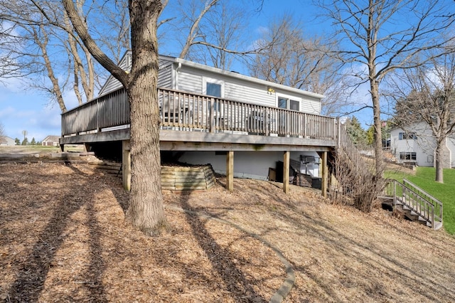 back of house featuring stairway and a deck