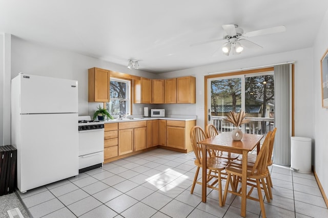 kitchen with white appliances, ceiling fan, a wealth of natural light, and light countertops