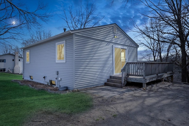 view of side of home with a lawn and a wooden deck