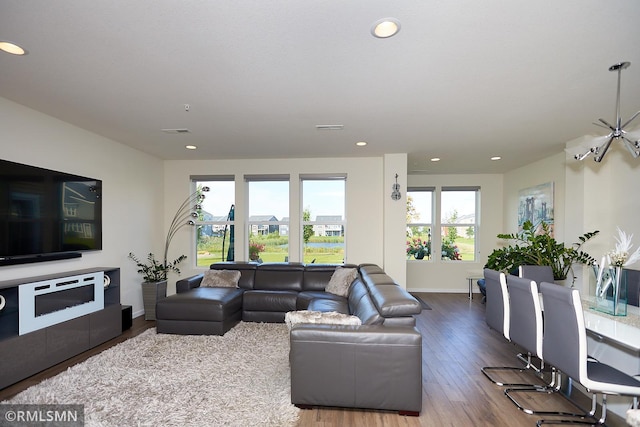 living area featuring recessed lighting, visible vents, baseboards, and wood finished floors