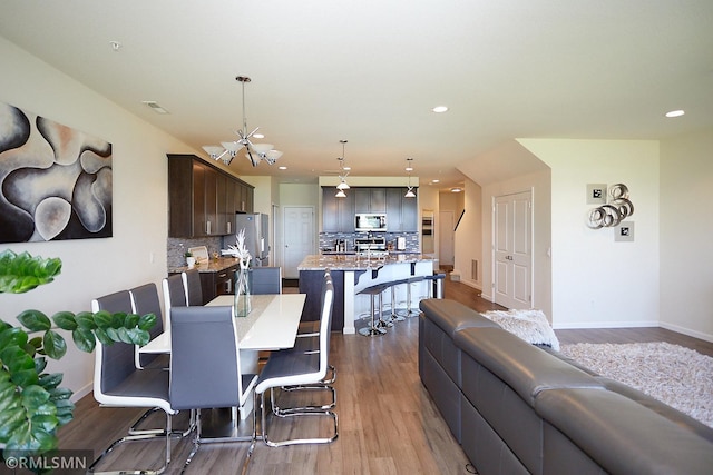 dining space with dark wood finished floors, visible vents, recessed lighting, and baseboards