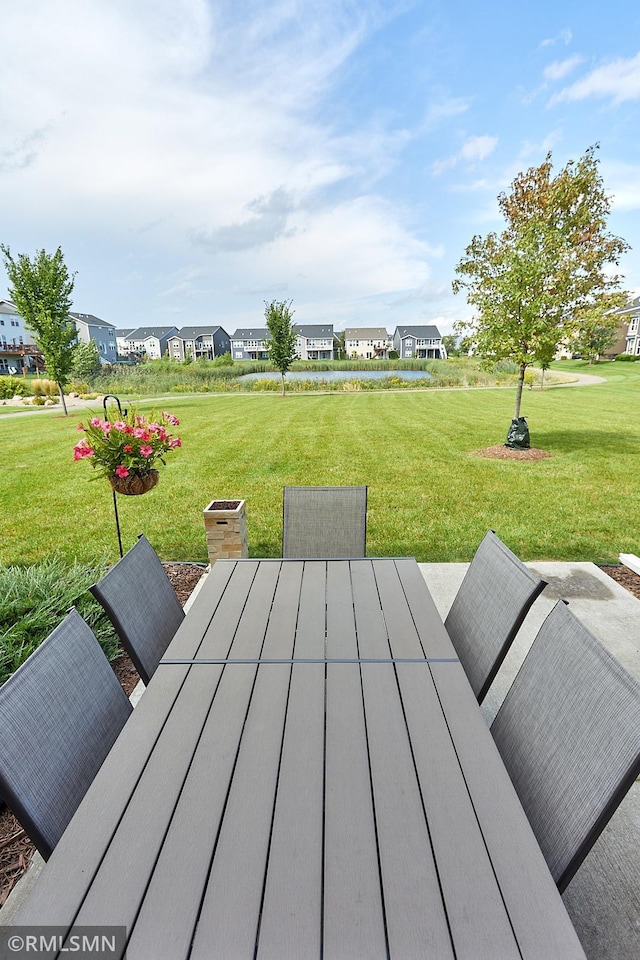 deck featuring outdoor dining space, a yard, and a residential view