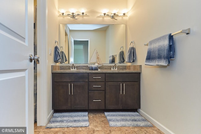 full bath featuring a sink, baseboards, and double vanity