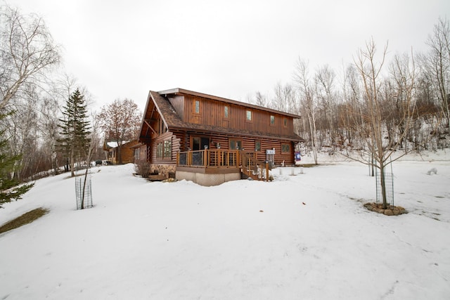 snow covered property featuring log exterior