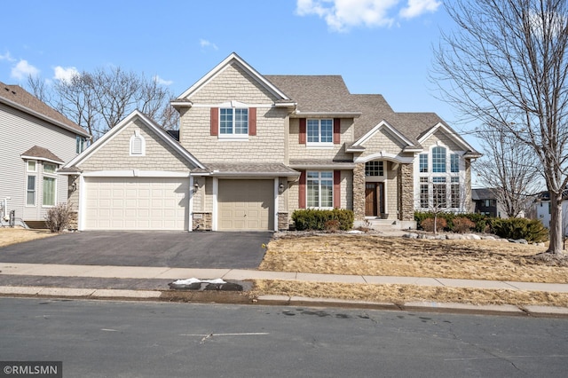 view of front facade featuring aphalt driveway, stone siding, and a shingled roof