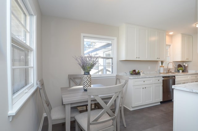 kitchen with a sink, white cabinetry, and stainless steel dishwasher