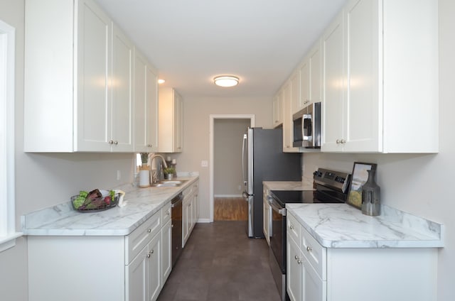 kitchen featuring a sink, white cabinets, baseboards, and stainless steel appliances