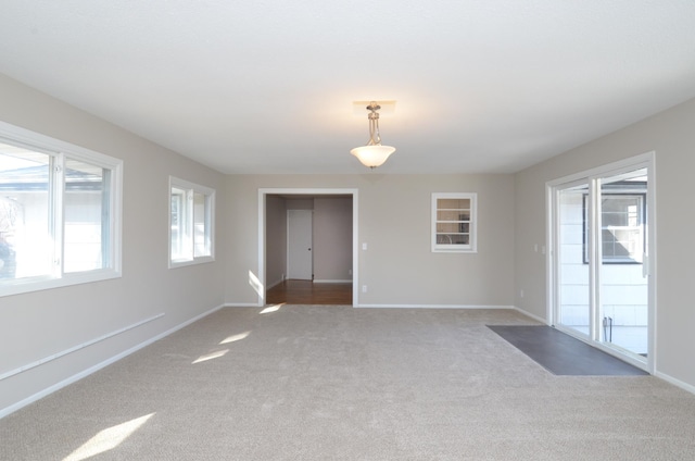 unfurnished room with carpet and baseboards