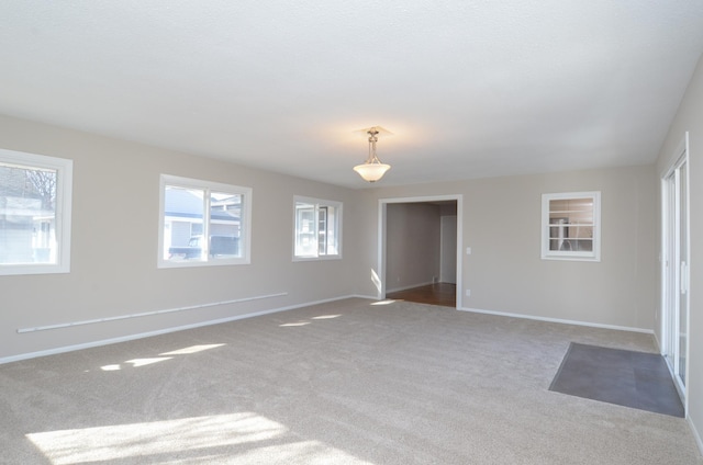 carpeted empty room with baseboards