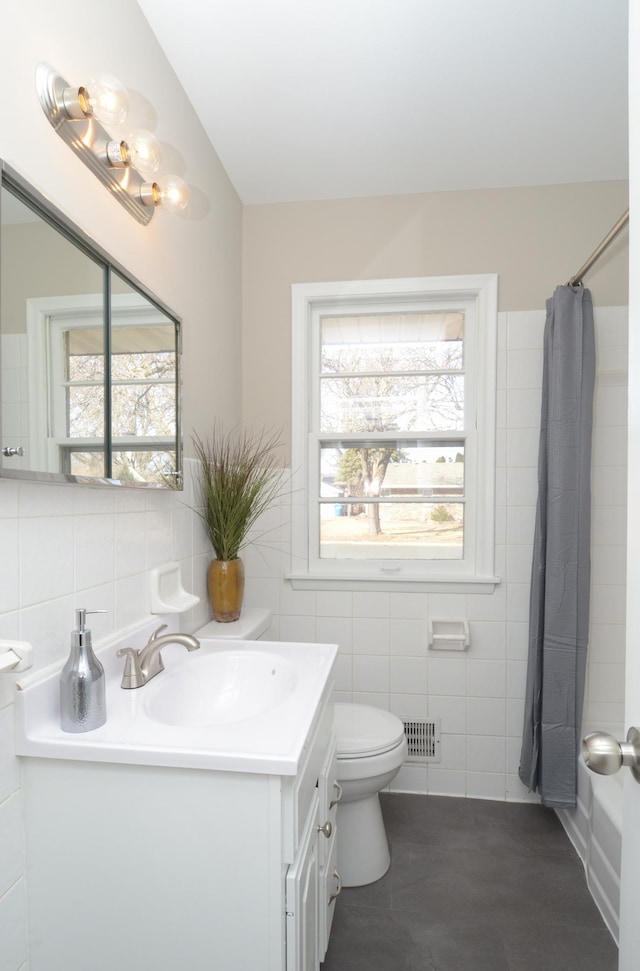 bathroom featuring a wealth of natural light, toilet, tile walls, and vanity