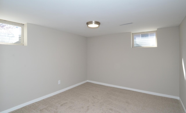 below grade area with visible vents, baseboards, and light carpet