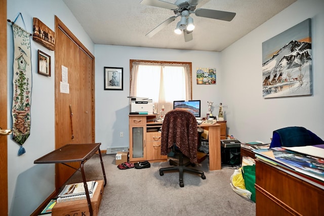 carpeted home office featuring ceiling fan and a textured ceiling