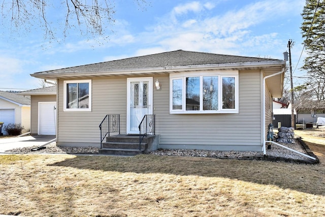 view of front of home with a garage, a front yard, and a shingled roof