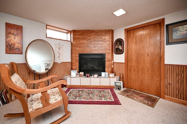 living room with wooden walls, wainscoting, a textured ceiling, and carpet