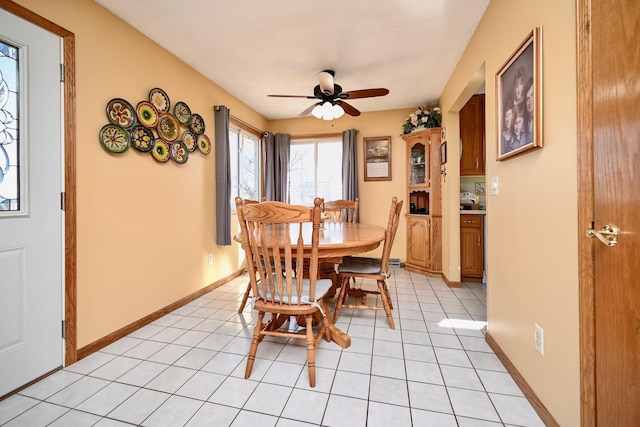 dining space featuring light tile patterned floors, baseboards, and ceiling fan