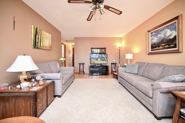 living area featuring a textured ceiling and a ceiling fan