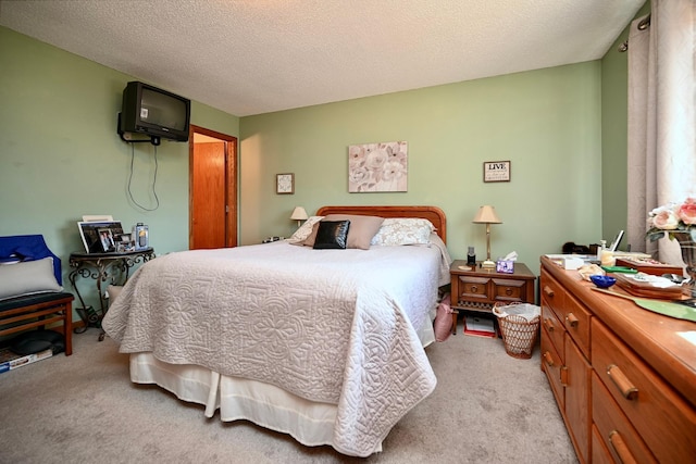 bedroom with light colored carpet and a textured ceiling