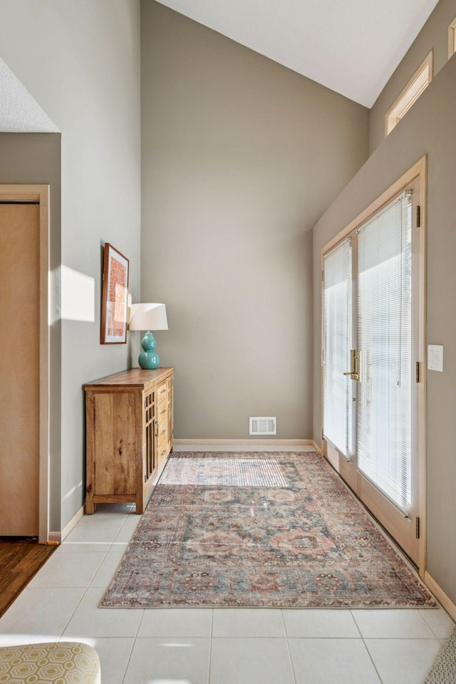 foyer featuring light tile patterned floors, visible vents, french doors, and baseboards