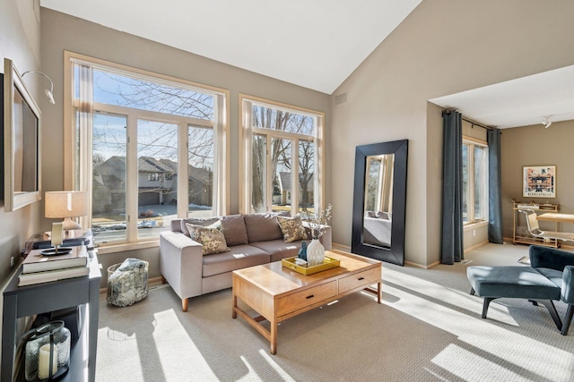 living room with baseboards, light colored carpet, and high vaulted ceiling