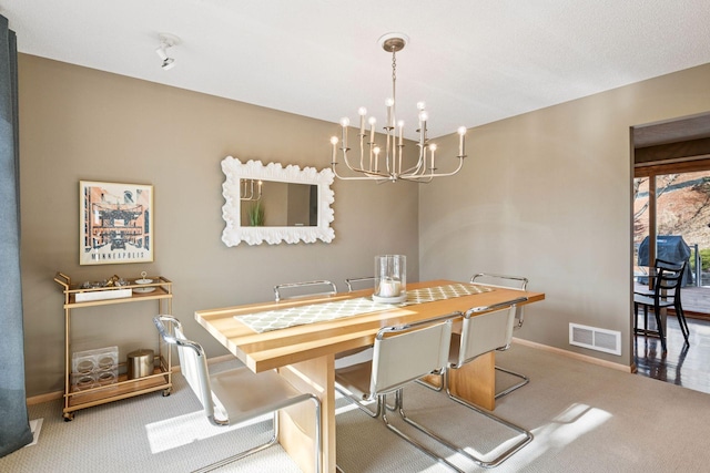 dining room featuring baseboards, visible vents, carpet floors, and a chandelier